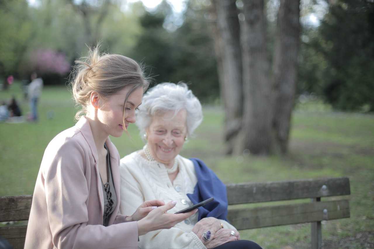 Young woman teaching an elder woman technology