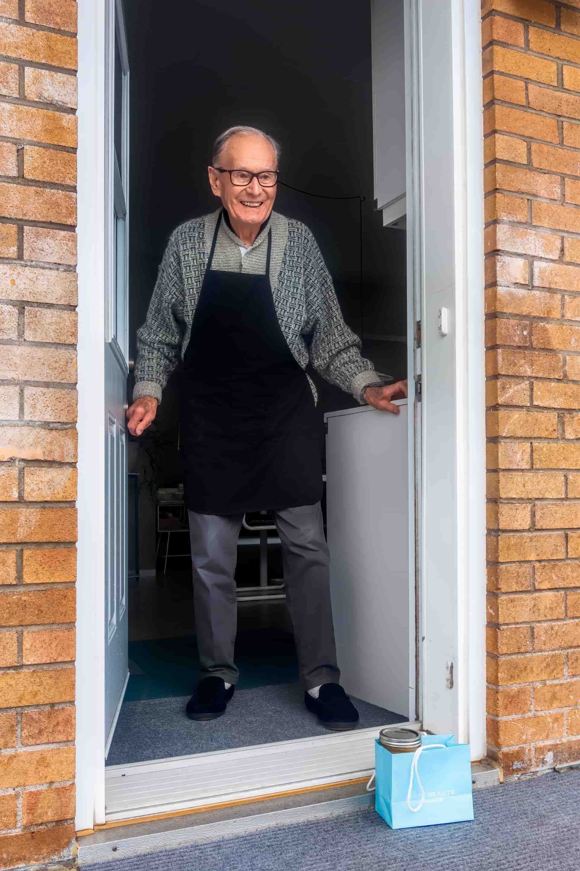 An elderly man exiting his home